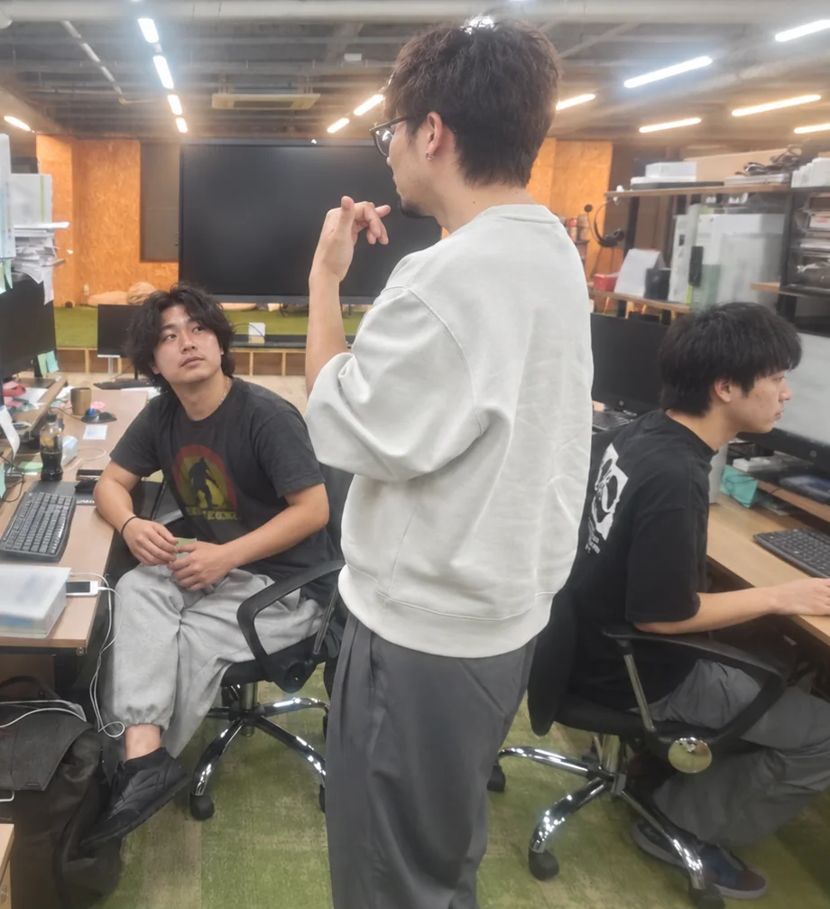 オフィスで相談しながら仕事を進めるスタッフ